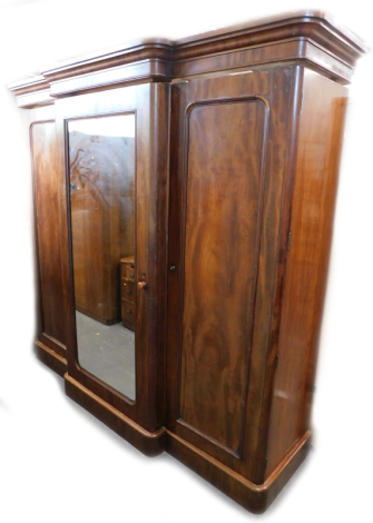 A Victorian figured mahogany triple breakfront wardrobe, with a moulded cornice above a mirrored door, flanked by two further panelled doors, on a plinth, (AF), 207cm high, 209cm wide.