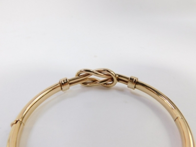 A hinged bangle, with two plait design central panel with three row bordering, yellow metal, stamped 375, 6.5cm wide, 12.6g all in. - 3