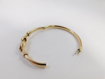 A hinged bangle, with two plait design central panel with three row bordering, yellow metal, stamped 375, 6.5cm wide, 12.6g all in. - 4