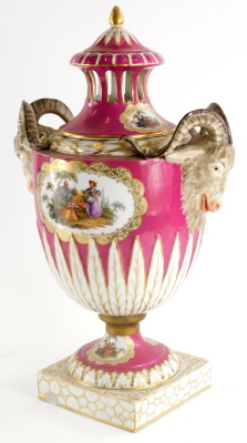 A late 19thC German porcelain two handled vase and cover, the lid with a gilt finial and pierced sides, the base decorated with rams head masks and figures within gilt cartouches, on a puce ground with leaf decorated base, the square plinth similarly deco