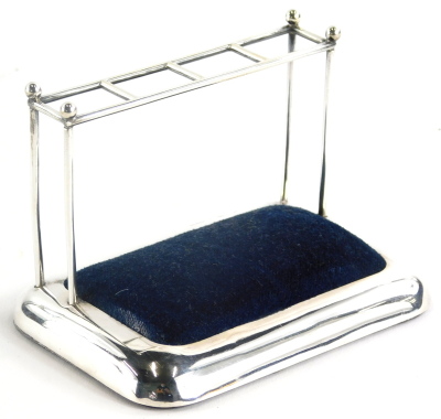 An Edwardian silver novelty hat pin stand, modelled in the form of an umbrella stand, with blue velvet pad, Chester 1904, by Sampson Mordan & Co, 12cm wide.