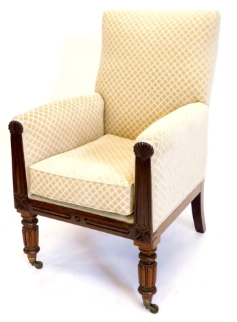 A William IV mahogany armchair, upholstered in patterned fabric, the channelled arm supports headed by carved shells, on turned fluted legs with brass castors.