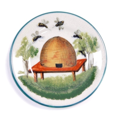 A Wemyss late 19thC pottery tea plate, decorated with a beehive and bees, retailers mark for TG Goode and Company, South Audley St, London, painted and impressed marks, 14cm diameter.