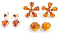 A group of imitation amber earrings, to include a pair of large silver flower cluster imitation amber earrings, a pair of silver drop amber earrings and a pair of 9ct framed amber earrings, the silver earrings 12.1g, the others 2.9g. (3)