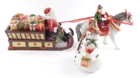 A Villeroy and Boch Christmas porcelain toy candle holder, modeled as Santa with his sleigh of toys, and an elf riding a horse, together with a nostalgic light modeled as a snowman. (2)