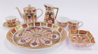 A Royal Crown Derby porcelain miniature solitaire tea set, decorated in the Olde Imari pattern, comprising oval tray, teapot, cream jug, sugar bowl, teacup and saucer, together with a square pin dish, and an Imari pattern pitcher. (a quantity)