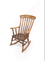 A Victorian oak and elm lath back rocking chair, with solid saddle seat, raised on ring and baluster turned legs united by a double H frame stretcher.