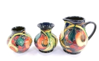 A group of Moorcroft pottery decorated in the Queen's Choice pattern, c2000, painted and impressed marks, comprising a milk jug, 12cm high, baluster vase, 9.5cm high, and a further vase, 8.5cm high, all seconds. (3)