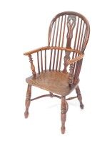 A 19thC yew and elm Windsor chair, with a vase shaped splat, solid saddle seat, raised on ring turned legs united by a crinoline stretcher.