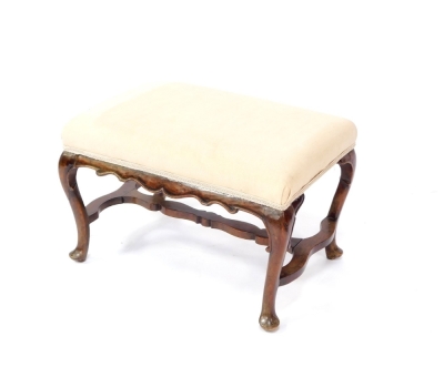 A Georgian style mahogany stool, upholstered in overstuffed cream draylon, raised on cabriole legs, united by a shaped stretcher, 61cm wide.