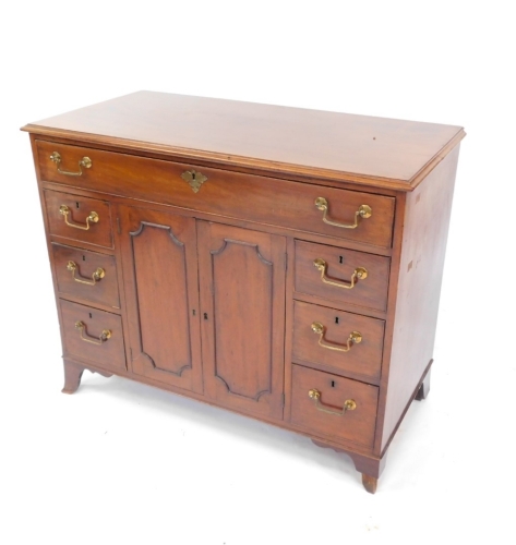 A Georgian style mahogany side cabinet, with a three division long drawer, over a pair of cupboard doors, opening to reveal a single shelf, flanked by six drawers, raised on out swept feet, 86cm high, 107cm wide, 52.5cm deep.