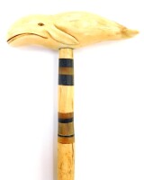 A 19thC walking cane, the marine ivory handle carved as a whale, mounted on a whale bone shaft with baleen rings, 87cm high.