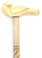 A 19thC walking cane, with a marine ivory handle carved as a bird, on a wrythen turned whale bone shaft, 89cm high.