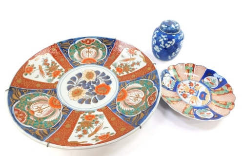 A Japanese Imari charger, decorated with birds and flowers, 40cm diameter, together with a Chinese fluted dish and a blue and white ginger jar and cover decorated with prunus blossom against a cracked ice ground. (4)