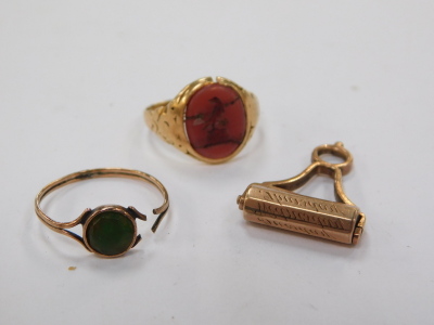 A carnelian crested signet ring, set in yellow metal, size K, further ring, and a roller seal, with engraved named detailing, yellow metal, 6.5g all in.