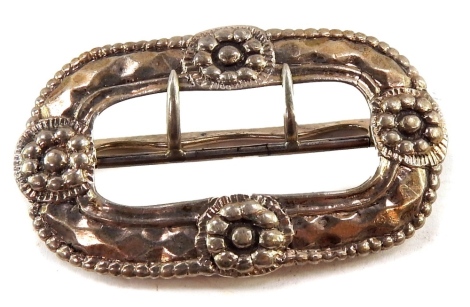 A 19thC buckle, white metal, embossed with flowerheads, bears marks, 8cm wide.