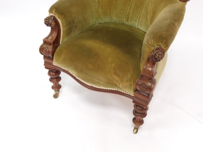 A Victorian carved mahogany open spoon back armchair, with studded back, plain arms and serpentine seat, heavily carved with flowerheads and fruits to the curved top rail, with heavily carved inverted arms on triple turned legs terminating in castors, 112 - 3