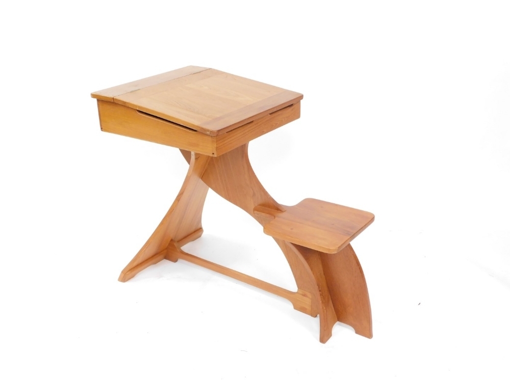A 20thC one piece child's desk, with lift up lid raised above fixed