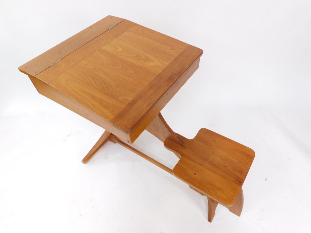 A 20thC one piece child's desk, with lift up lid raised above fixed