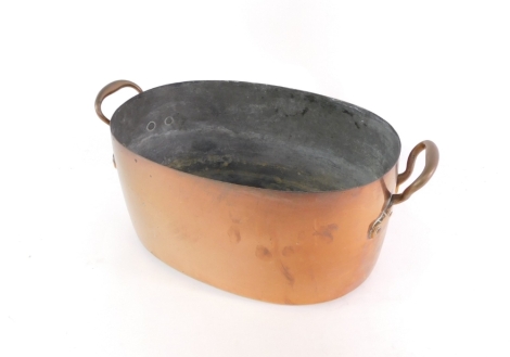 A late 19th/early 20thC copper fish kettle, of oval form with molded handles and studded mounts, 20cm high, 45cm wide.