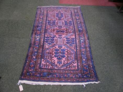 An early 20thC Caucasian rug ground in blue and red