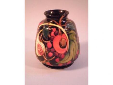 A modern Moorcroft vase with typical tube lined decorated of fruit