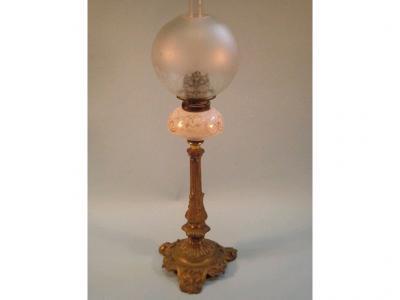 A Victorian gilt metal oil lamp with a white opaque glass reservoir decorated