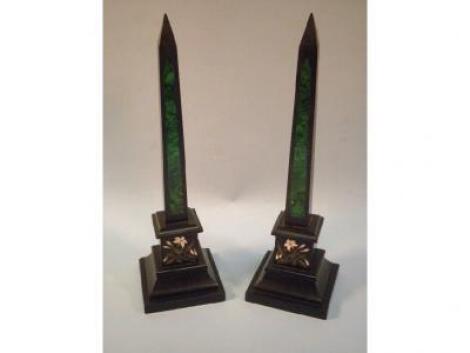 A pair of 19thC black marble and malachite inlaid obelisks