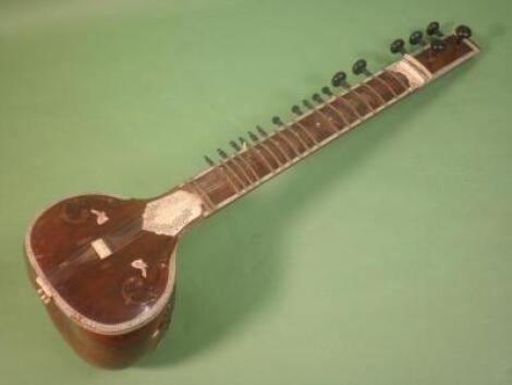 A 20thC Indian sitar, applied and inlaid with bone, with ebonised and brass fittings