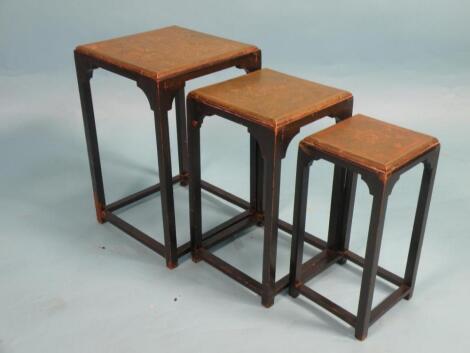 A nest of three ebonised tables