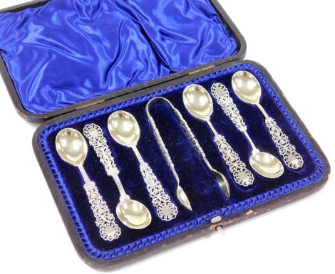 An Edward VIII Arts and Crafts silver spoon and sugar tong set, with pierced and scroll decoration, makers stamp HH, Sheffield 1909, in a blue lined velvet fitted case, 4½oz.