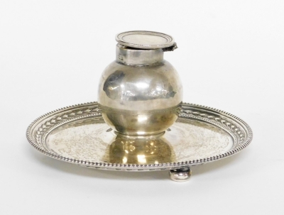 An Edward VII silver inkwell and stand, the bulbous shaped inkwell on a circular tray base, with fluted and ribbed borders, on three bun feet, makers stamp JD&S, Birmingham 1904 (AF), 7cm high, 13cm wide, 6½oz gross.