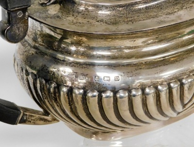 A George V silver three piece tea service, comprising teapot, milk jug, sugar bowl, the teapot with ebonised handle and knop, on a fluted body, Birmingham 1928, 39½oz gross. - 2