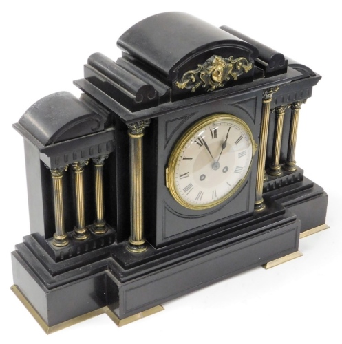 A late 19thC black slate mantel clock, with applied brass detailing on Corinthian column supports, on a stepped base, with eight day movement and pendulum, 37cm high, 50cm wide, 18cm deep.