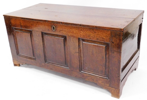 A late 17thC oak coffer, with three panelled front with brass escutcheon, 56cm high, 117cm wide, 54cm deep.