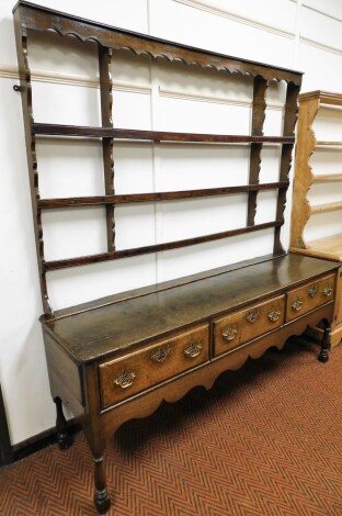 A late 18th/early 19thC oak dresser, the dresser back rack on sideboard with three drawers, with brass pierced handles, on part turned supports, 206cm high, 192cm wide, 51cm deep.