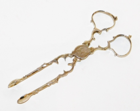 A pair of early 19thC silver sugar tongs, with rococo scrollings, bearing the initial MB, with seal stamp to clasp, 1oz.