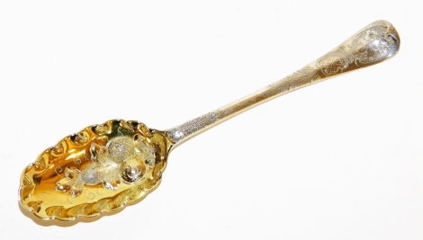 An 18thC silver berry spoon, the stem with floral leaf engraving, later embossed with three berries on a gilt finished spoon, hallmarks rubbed, 20cm long, 2¼oz.