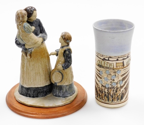 Two items of studio pottery, to include a studio pottery stem vase, signed Gough, and dated 95, of Fenland scene, with flowers, on a ribbed and flared body, 22cm high, together with a stoneware sculpture of lady carrying child talking to another figure, 2