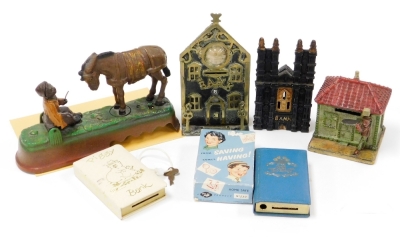 A group of novelty and other money boxes, to include a Cathedral Bank, a bank with clock aperture, a donkey and boy scene, a piggy bank book From Saving Comes Having, novelty saving bank and a miniature house and figure bank. (6)