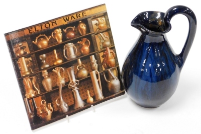 An Eltonware pottery jug, circa 1900, in a blue glazed decoration with Eltonware information book, 26cm high. (2)