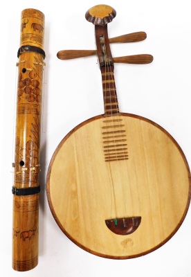 Two wooden instruments, to include a Valiha and a Yuegin Chinese moon guitar.