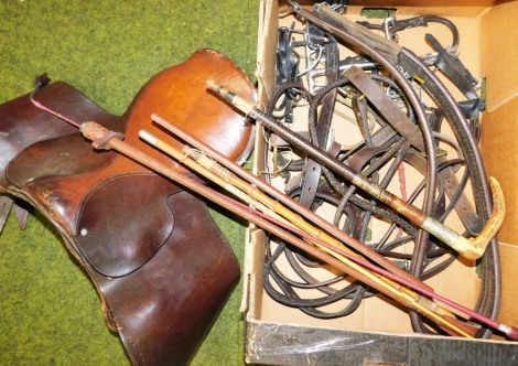 Various riding accessories, to include a saddle, various whips, horse hames, etc. (a quantity)