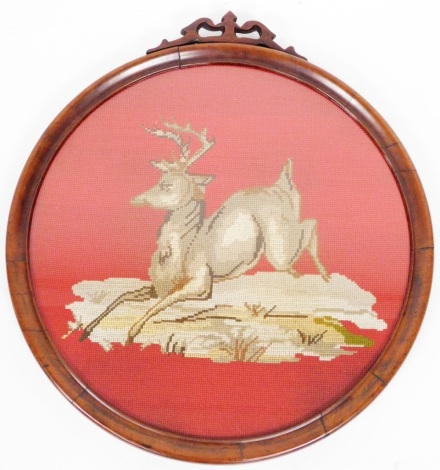 An early 20thC mahogany framed circular tapestry of a stag, on a red ground, 40cm diameter.