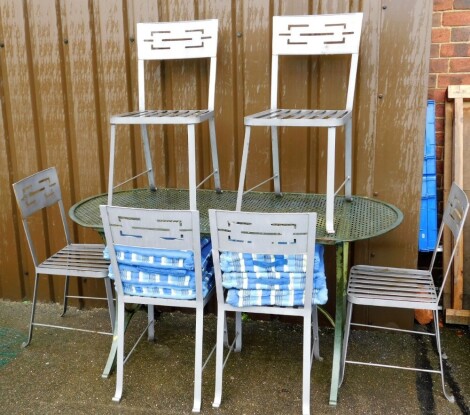 A metal pierced garden table with six associated chairs, the table 77cm high, 144cm wide, 81cm deep.