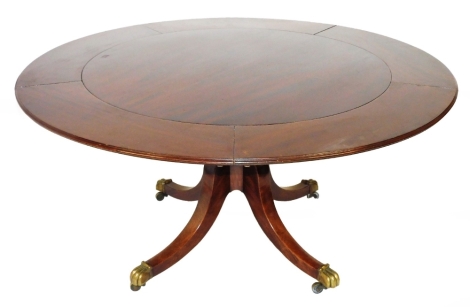 A Regency mahogany 'Jupe' type circumferential extending breakfast/dining table, the later top having five add-on leaves to the border, supported on a period quadruped base with turned support and brass claw feet and castors, 72cm high, 108cm min. & 151cm