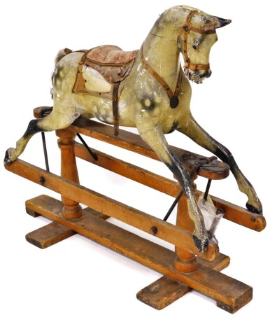 A late 19thC rocking horse, of a dapple grey horse, on pine supports (AF), 104cm high, 120cm wide, 25cm deep.