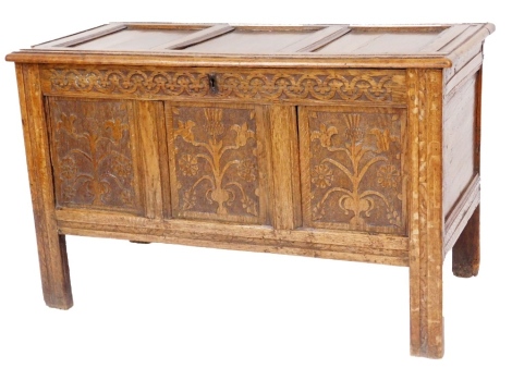 A carved oak coffer, the three panelled top above a carved front on stiles, 68cm high, 108cm wide, 51cm deep.