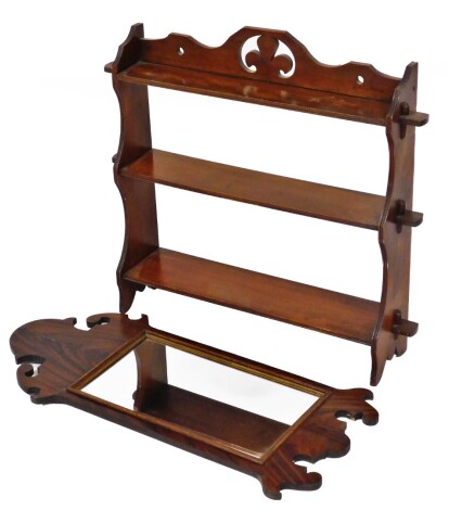 Two items of furniture, to include a mahogany fret framed rectangular wall mirror, 74cm high, 35cm wide, and a walnut three tier hanging shelf, with three leaf clover carved frieze, 64cm high, 63cm wide, 15cm deep. (2)