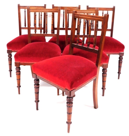 A set of six late 19thC mahogany dining chairs, each with three turned back supports, red padded upholstered seats, 86cm high, 40cm deep.